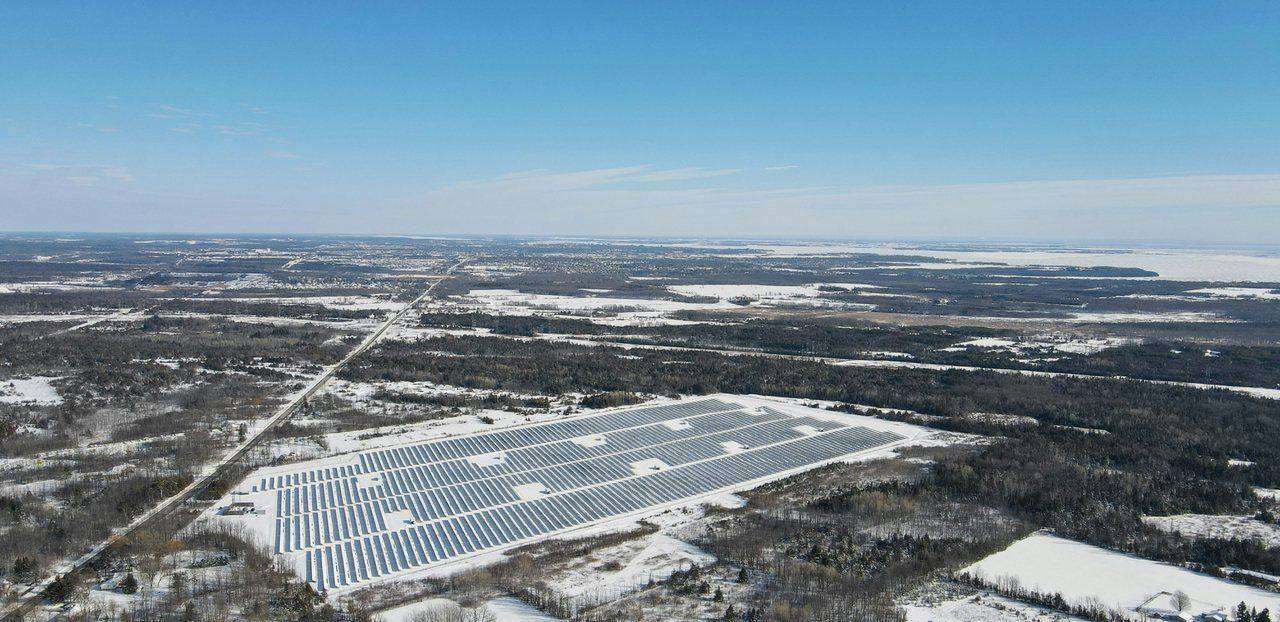 Aerial winter view of solar panel farm in snowy fields