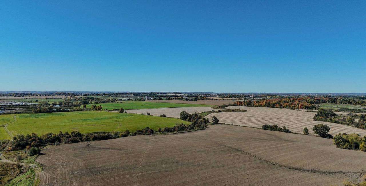 Aerial view of patchwork farmland under a wide blue sky