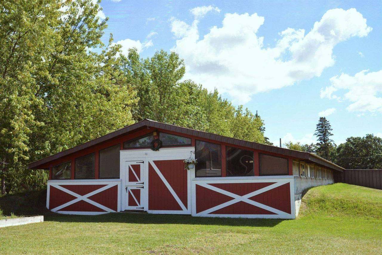 Red and white barn-style building among trees