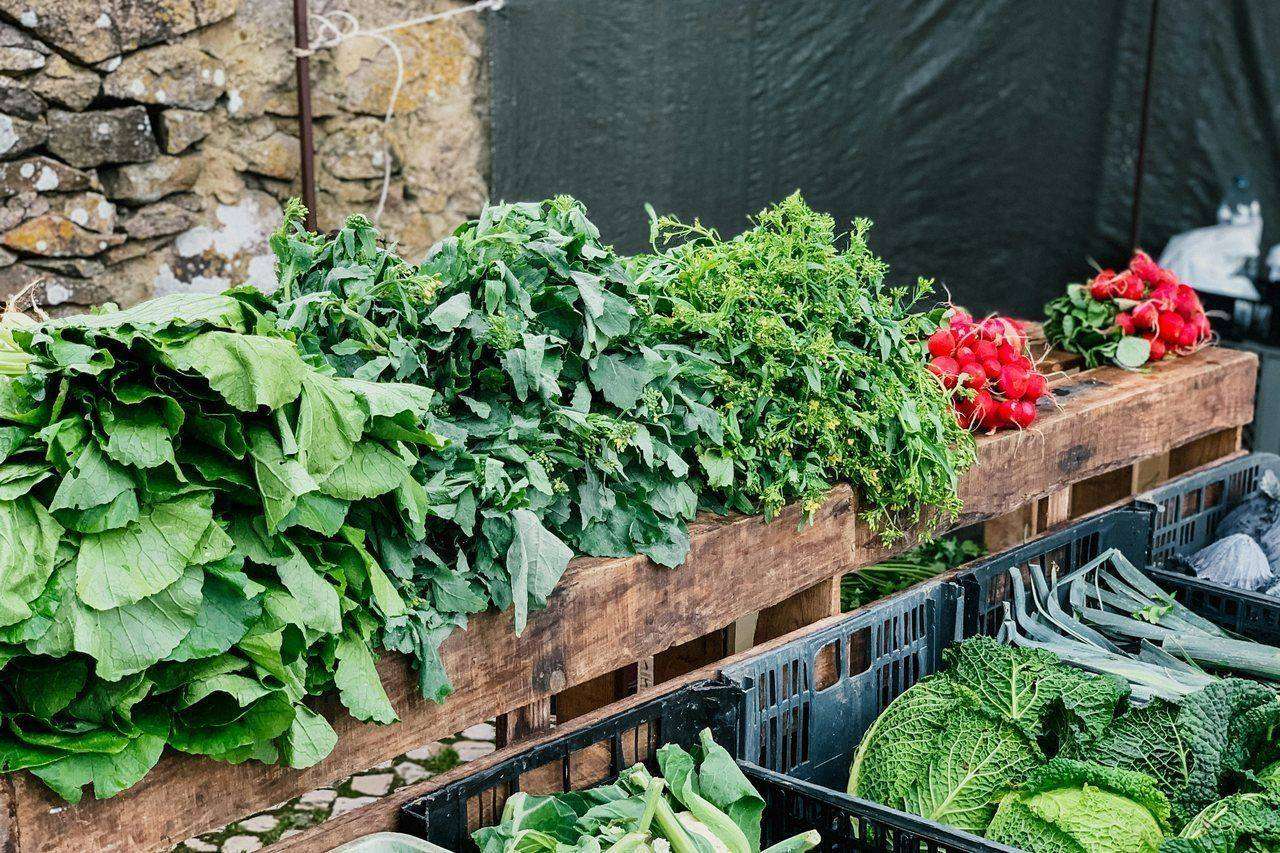 Fresh greens and radishes displayed on market stand