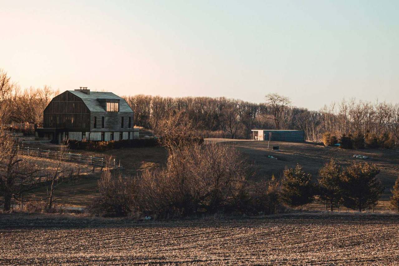 Farmhouse beside a plowed field at golden hour