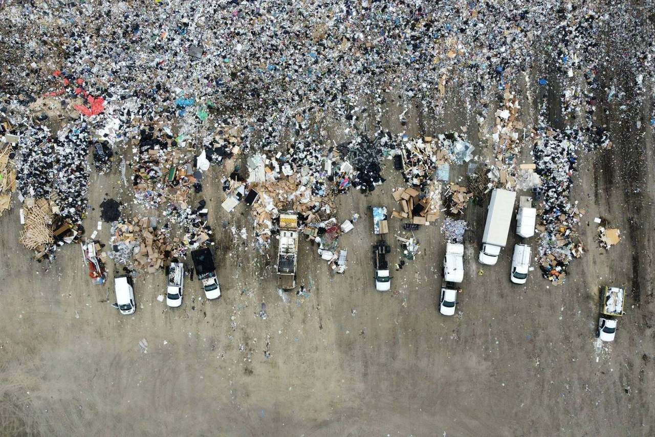 Aerial view of landfill with trucks sorting debris